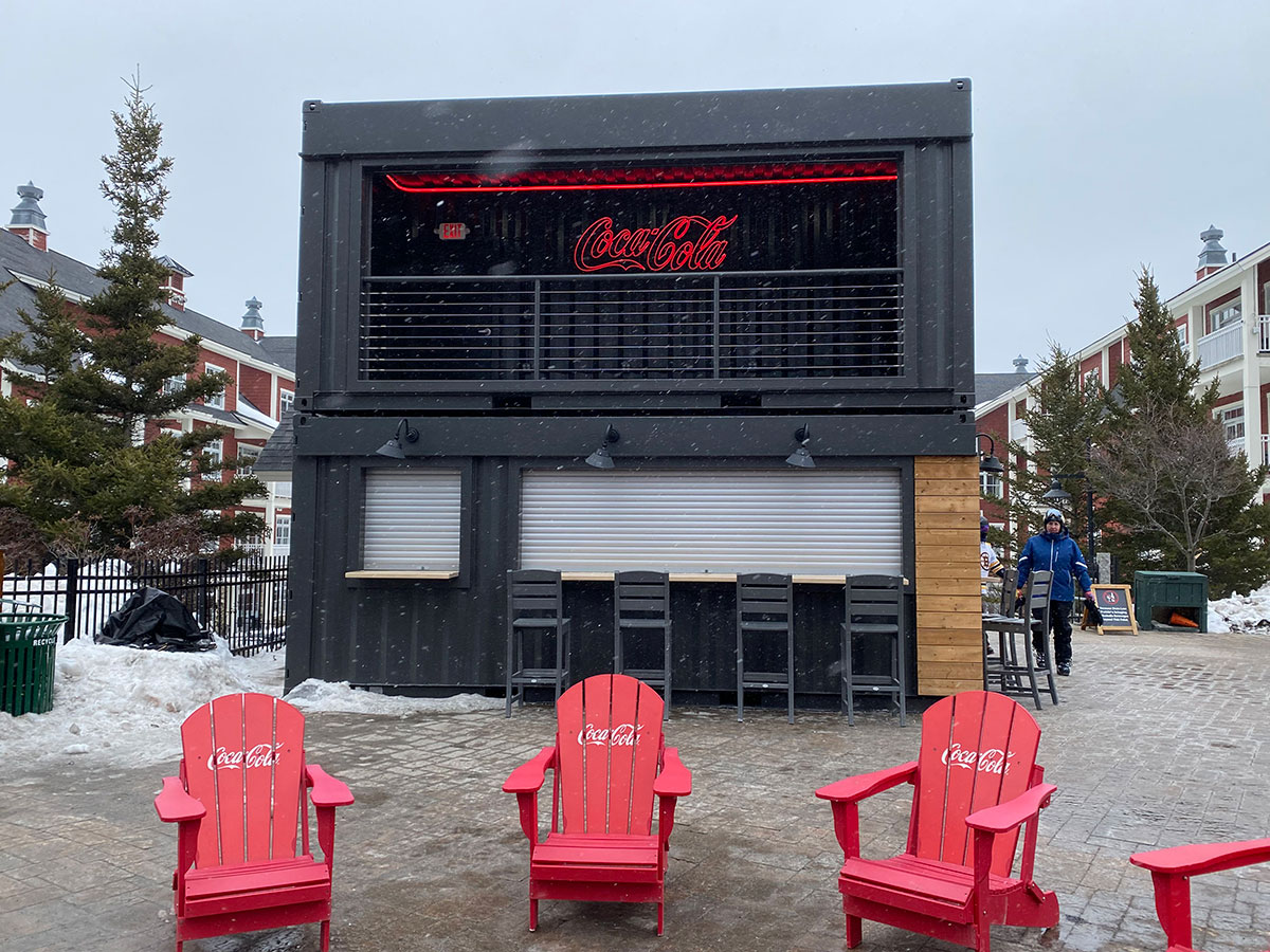 Coca-Cola shipping container bar activation at a snowy village